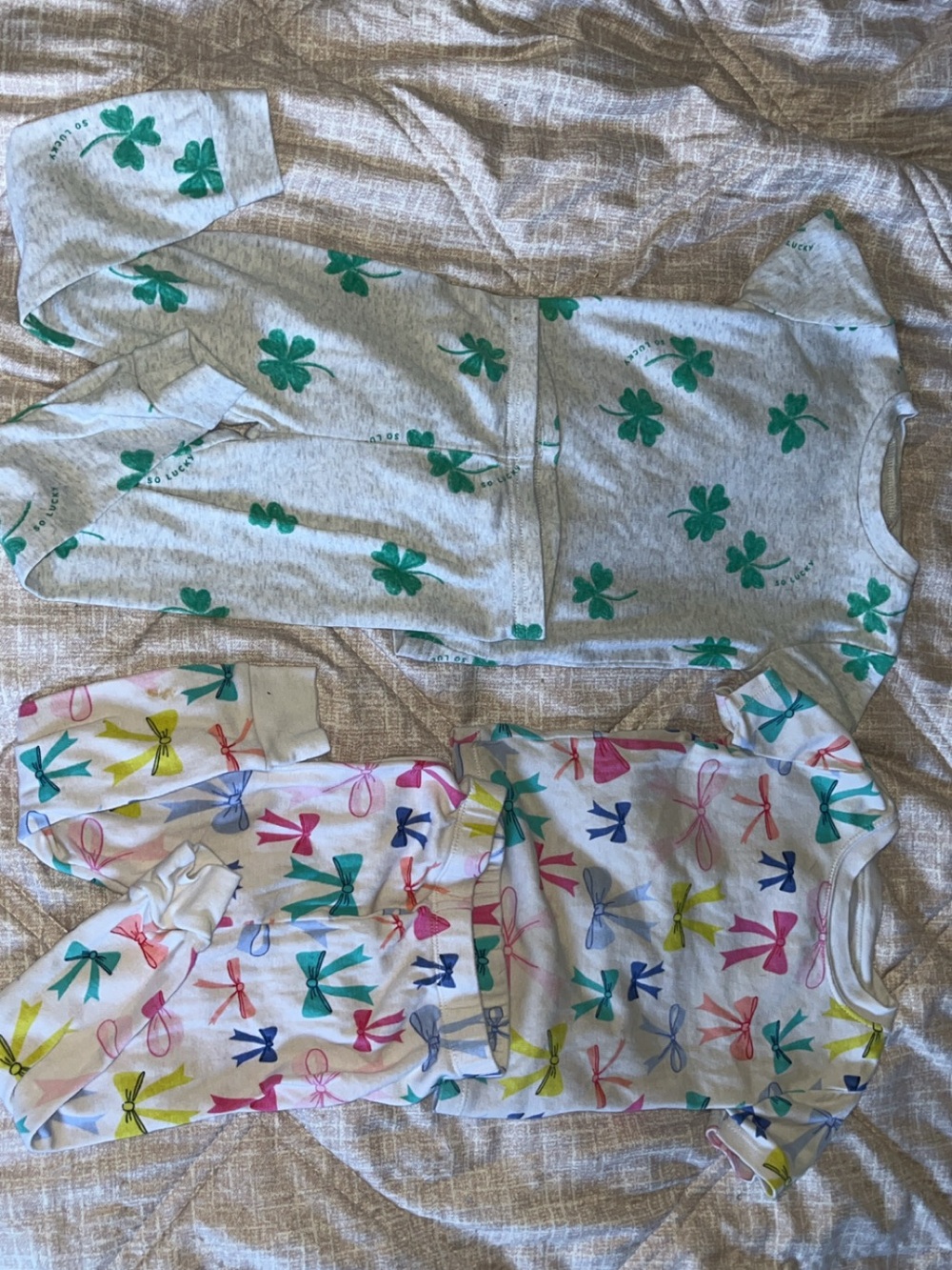 Size 2T bundle of two pajamas. Bows and clover designs. Great condition!